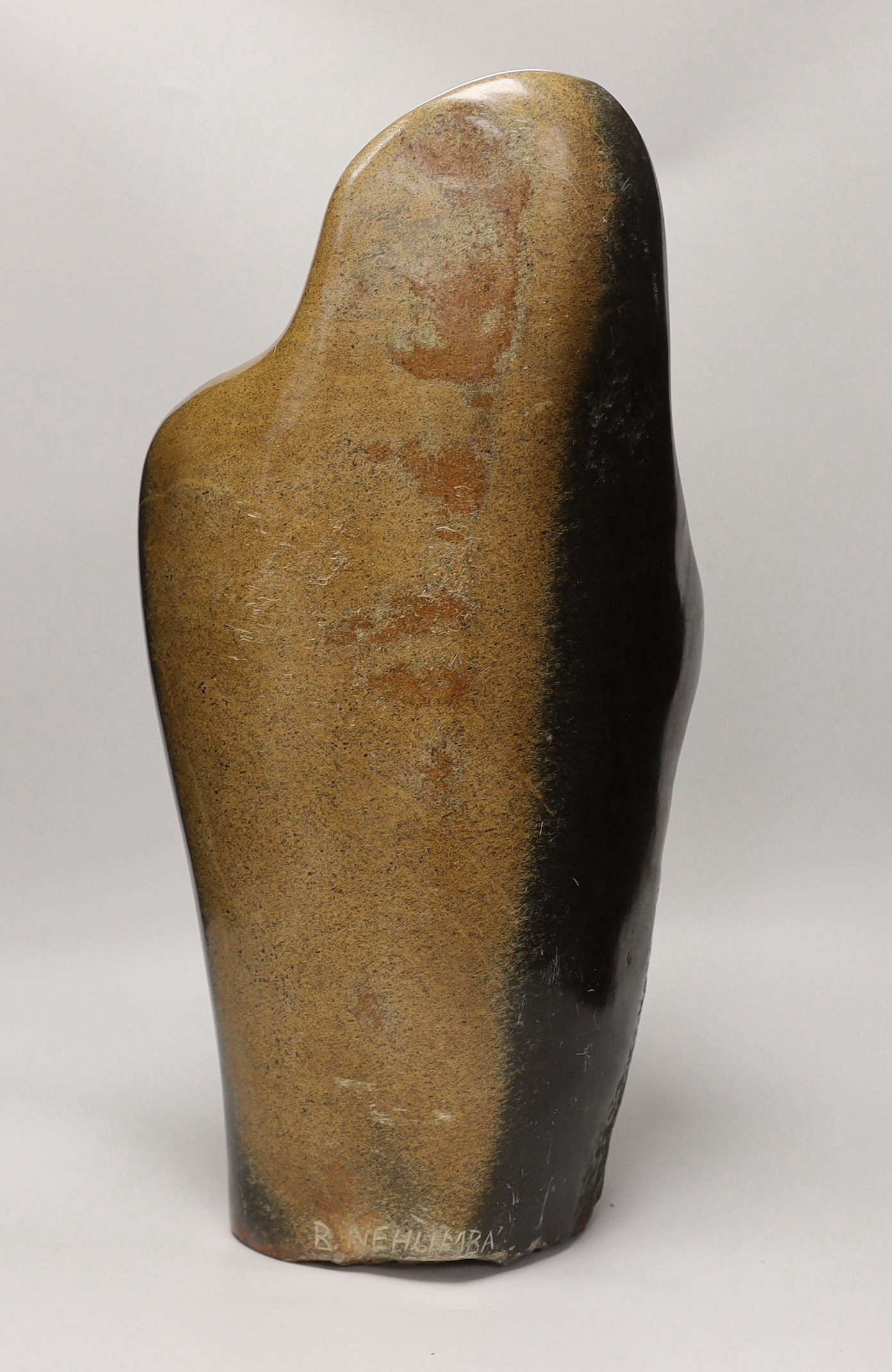 A Zimbabwe soapstone carving of two embracing figures, signed B Nehlimba, 53cm high